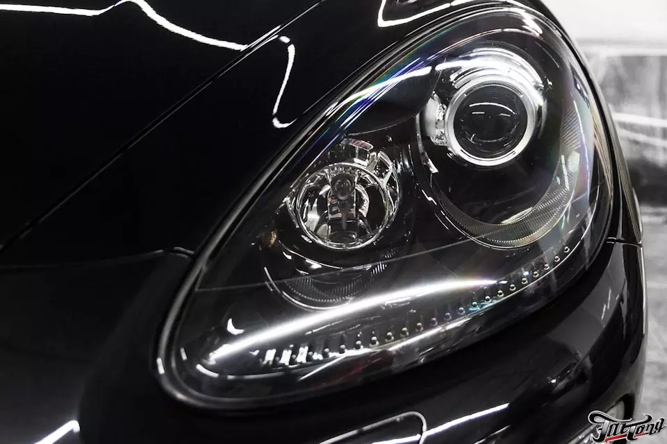 Porsche Cayenne. Окрас нижнего текстурного пластика в цвет кузова и окрас масок фар в черный глянец.